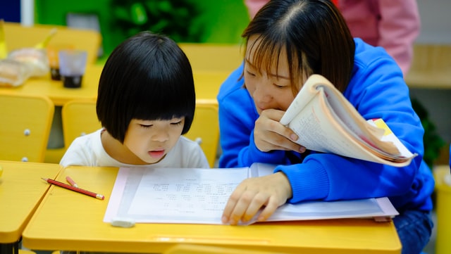 大人が子供に勉強を指導する